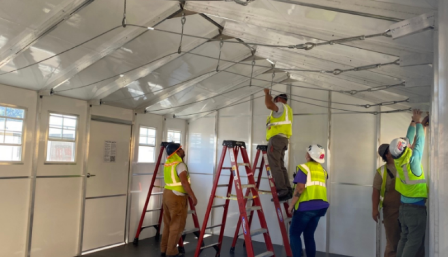 Construction workers assembling a dining hall for the Grover Beach temporary housing.