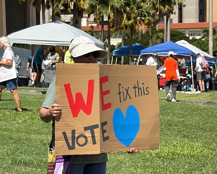 A participant holds a sign at the No Dictators rally at the Hawaiʻi State Capitol on Oct. 17, 2026.