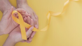 adult and child hands holding yellow gold ribbon, Sarcoma Awareness, Bone cancer, childhood cancer awareness, world suicide prevention day, September Yellow