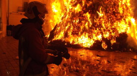 A firefighter works to put out a fire