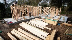 A house is framed in wood at a construction site. 