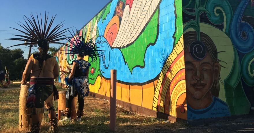 Members of Grupo Tlaloc Danza Azteca drum and dance at a ceremony to celebrate newly restored murals on a building at 2895 West 8th Avenue in Denver.