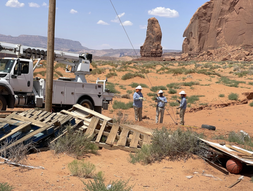 Workers from Alabama-based Dixie Electric Cooperative connect a newly installed power pole to the grid at the home of Persephonie Blackwater in the Navajo Nation.

