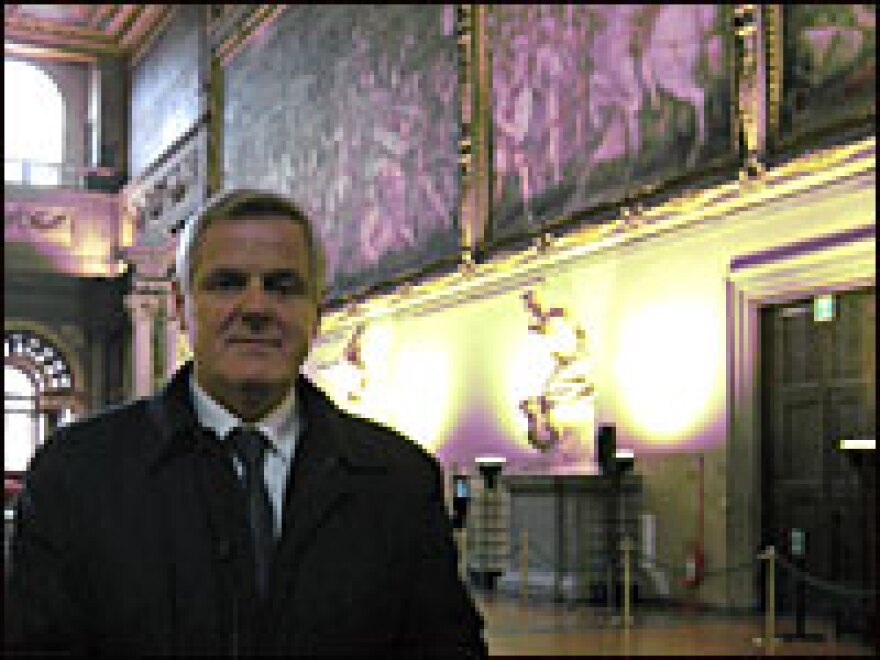 Engineer Maurizio Seracini stands in Florence's Palazzo Vecchio with Vasari's wall paintings in the background.