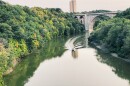 A boat in the Genesee River heading away from the trail bridge