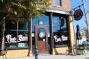 The Pour Brothers Taproom has an attractive facade with signage along the widows and an attractive sign hanging from the front of the building.