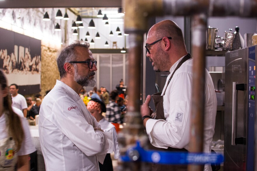 Chefs Massimo Bottura and Carlos Garcia talk in the kitchen during the dinner service.