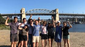 Group of people raising their hands on a beach. 