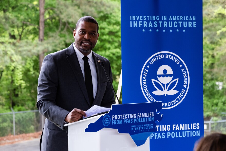 Environmental Protection Agency Administrator Michael Regan, wearing a suit, speaks at a podium in Fayetteville, NC on April 10, 2024 to announce the first-ever PFAS drinking water standards. 