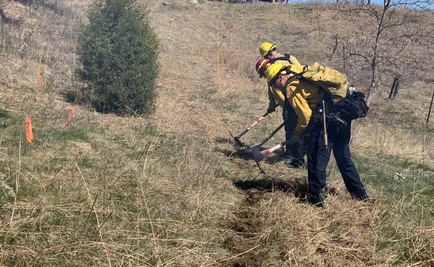 Before hoses are rolled out, crews begin to make an artificial fire break