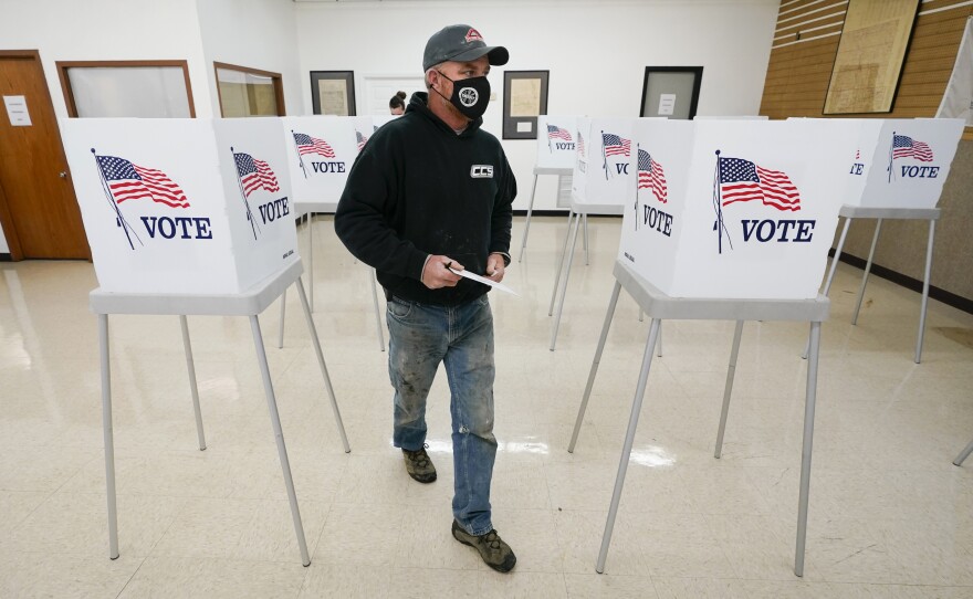 Chris Helps of Earlham, Iowa, makes his way to the ballot box during early voting on Oct. 20 in Adel, Iowa.