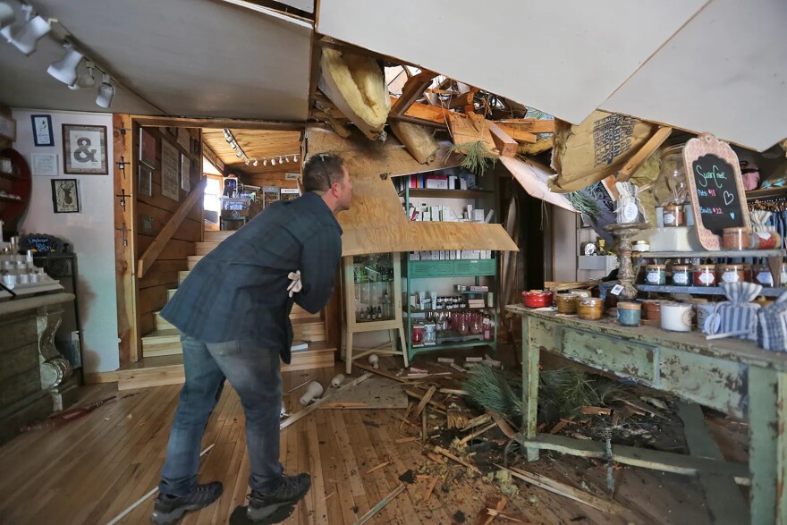 Eric Vaughn surveys the wind damage to his roof at the Unique Boutique in Ruidoso, N.M., on Wednesday.