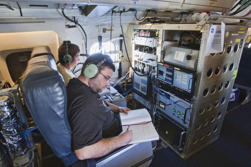 Terry Lathem, a graduate student in Georgia Tech's School of Earth and Atmospheric Sciences, takes notes aboard a NASA DC-8 aircraft gathering samples of microorganisms in the atmosphere.