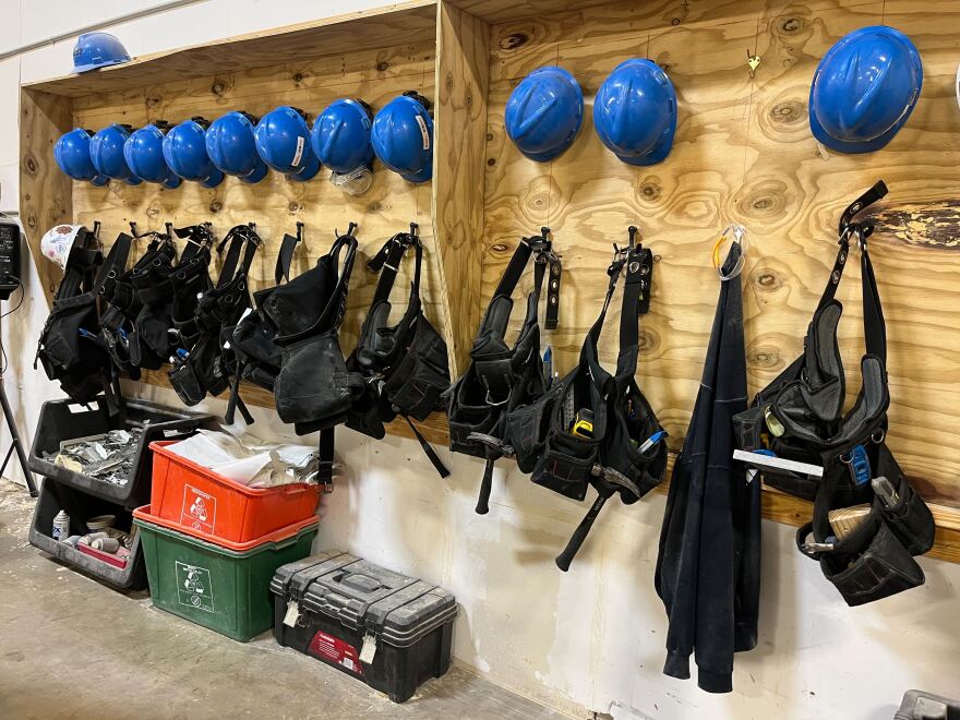 A row of hats and toolbelts hang waiting for students at the Home Builders Institute in Orlando.