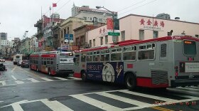 San Francisco Municipal Transportation Agency buses driving down a street.