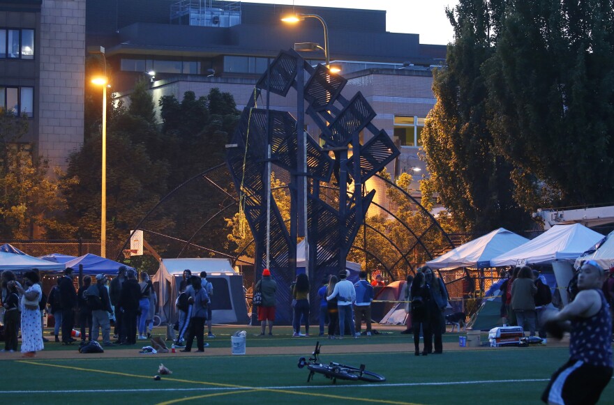 Activists work to install a large wooden fist in the occupied zone on Wednesday.