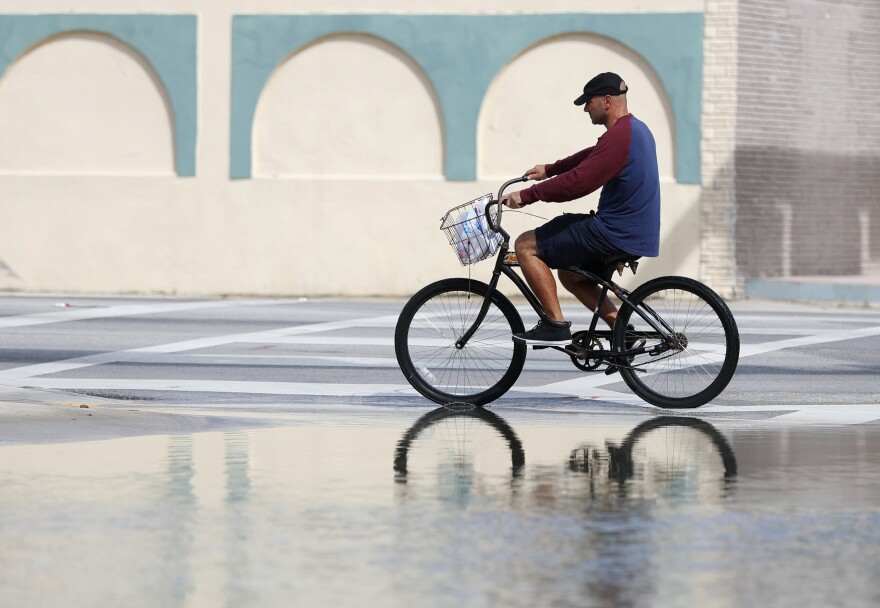 A cyclist rides past an area flooded during a King Tide, an especially high tide, in Miami, Florida on Oct. 9, 2018. Federal scientists, according to a report released on July 10, 2019, predicted 40 places in the U.S. will experience higher than normal rates of so-called sunny day flooding that year due to rising sea levels and an abnormal El Nino weather system.