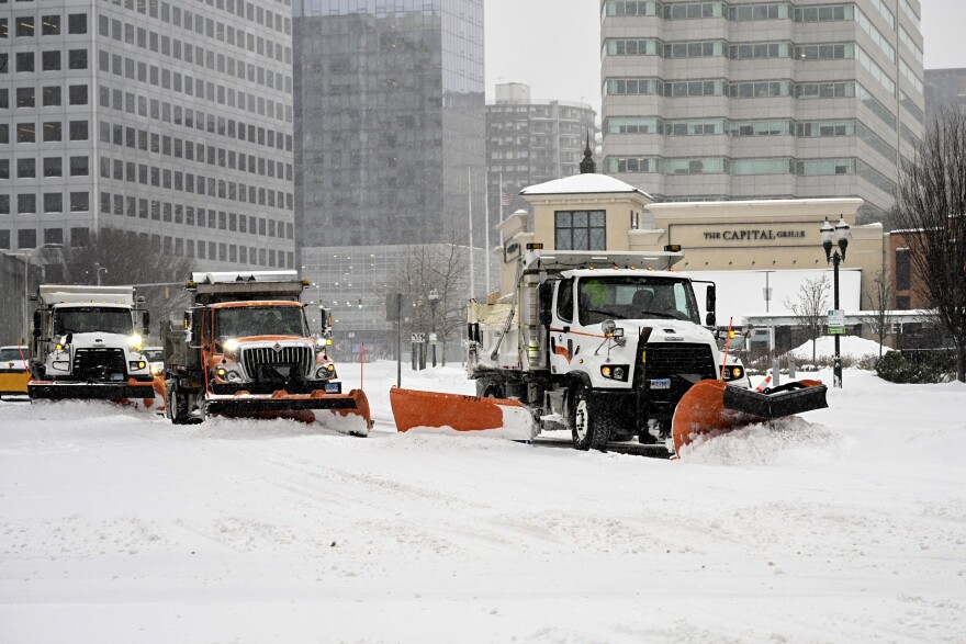 Three plow trucks clear snow as they pass along Tresser Boulevard in Stamford CT, on 1/25/26. CT DOT spokesperson Josh Morgan asked residents to stay away from the roads in order for the plow trucks to clear the roads.