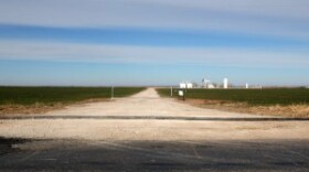 A water line for hydraulic fracturing crosses an oil-field access road in Woods County, Okla.