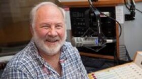 Tom Strekal is sitting in a KUNR studio. He is looking toward the camera while smiling.