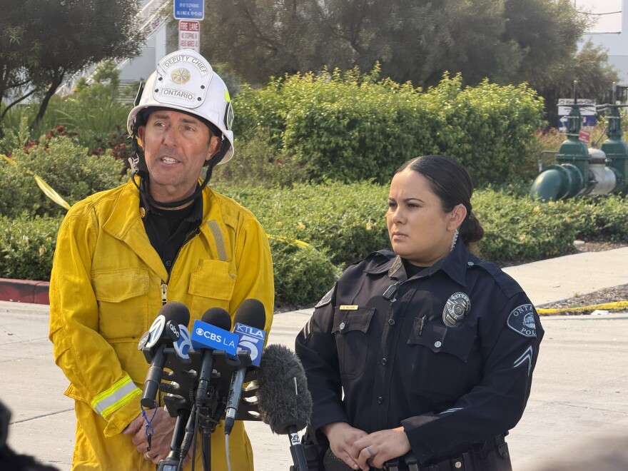Deputy Chief Mike Weddell, who helps lead operations for Ontario Fire Department (left), and Corporal Emily Williams, spokesperson for Ontario Police Department (right), speaking to the media during a press conference outside of the burned Kimberly-Clark warehouse on Tuesday, Apr. 7, 2026.