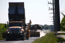 A Miami County highway crew chip-and-seals a road on July 30, 2026.