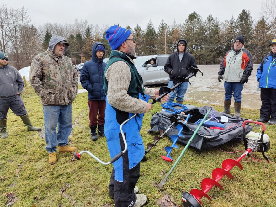 DEC Fisheries biologist Jim Everardt demonstrates ice fishing safety and gear at Casterline Pond in Cortland County. (Megan Zerez/WSKG)