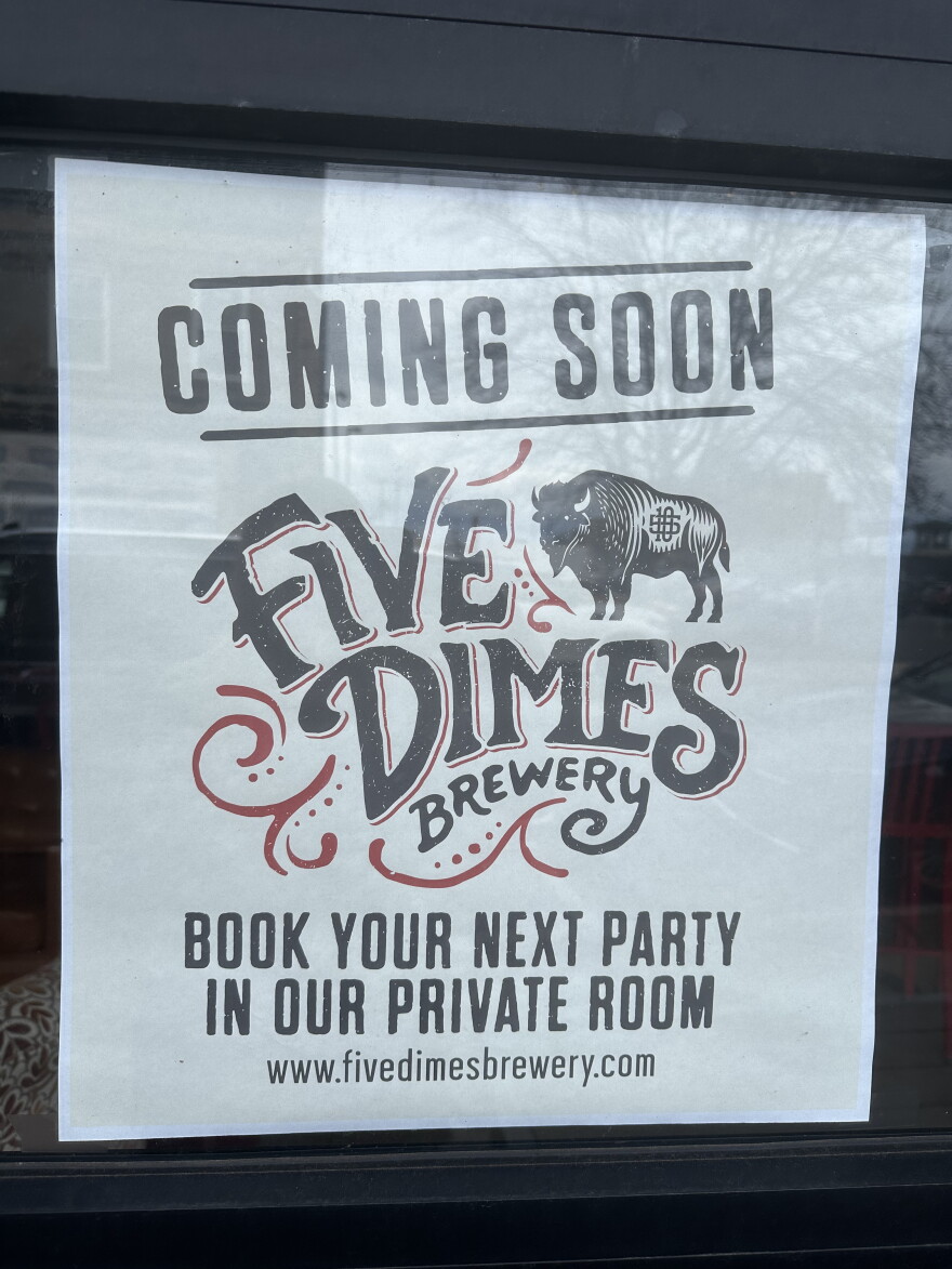 Sign hanging on the window of the former Red Tank Brewing space