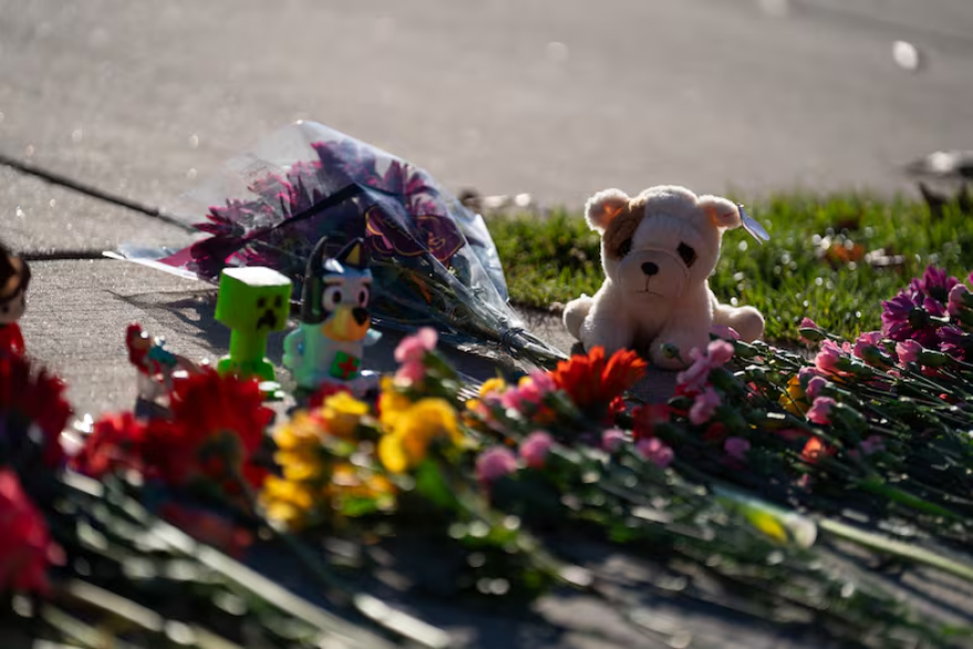 A stuffed animal and other items mark a makeshift memorial in front of Silver Rail Elementary School.