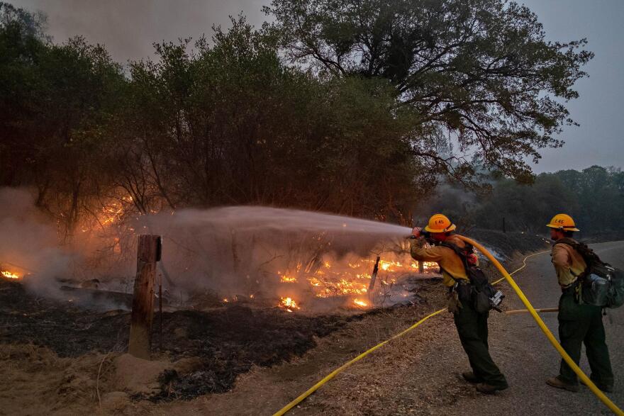 Firefighters from Sequoia Engine 45 cool off the edge of the burnout completed by the Springville Hotshots down a dozer line to Road 81 just north of the Mammoth Pools Trailer Park on the evening of September 10, 2020 as containment efforts continue on the Creek Fire.