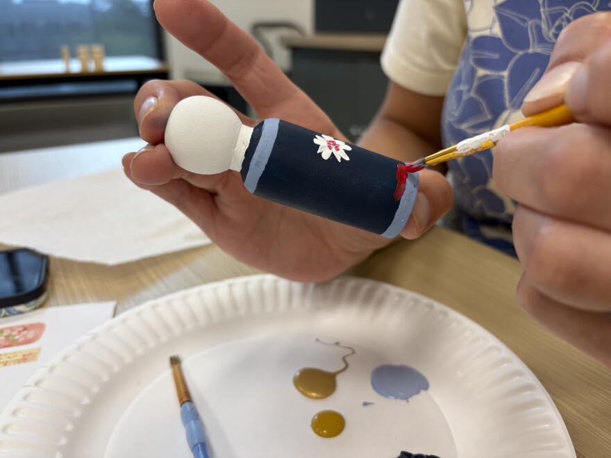 painting a blue wooden doll