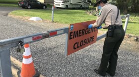 Washington State Parks area manager Audra Sims removes the “Emergency Closure” sign from the gate at Sacajawea Historical State Park, outside Pasco. The park re-opened to the public on May 5, after a nearly six-week closure. CREDIT: Courtney Flatt/NWPB