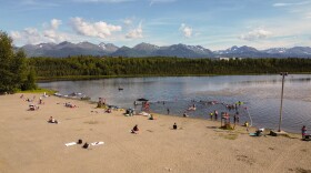 A abeach with people playing in the sand and the water