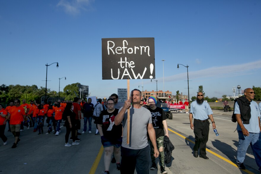 A United Auto Workers member holds a sign reading "Reform the UAW!" during a protest at a Labor Day parade in Detroit.