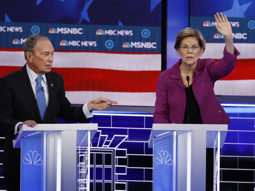 Sen. Elizabeth Warren, D-Mass., gestures during the debate as former New York City Mayor Michael Bloomberg looks on.