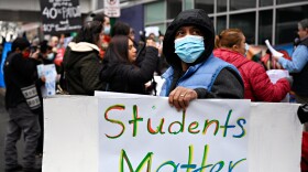 FILE: A protestor holds a sign in support of students in front of Gateway Community College at a march where protesters called for more funding for public schools and higher wages for teachers and paraprofessionals. The protesters marched from the New Haven Board of Education Central Office to City Hall.