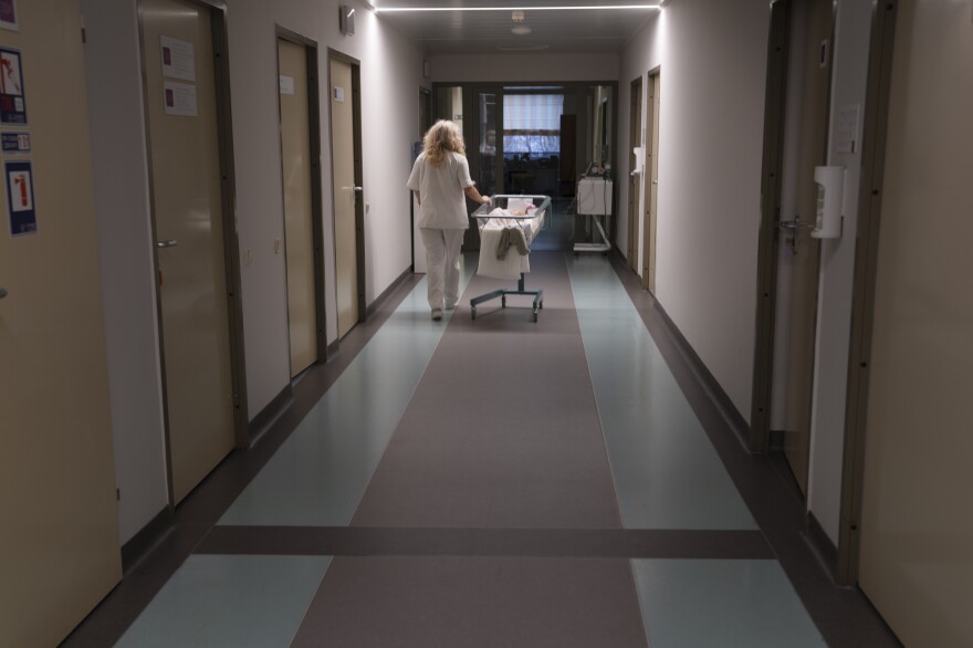 A doctor pushes a baby cart down the hallway in a maternity hospital in Kyiv.