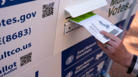 A voter drops off their ballot at a Multnomah County ballot drop box in Pioneer Courthouse Square in May 2026.
