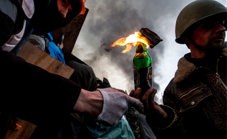 Anti-government protesters throw Molotov cocktails in Kiev's Independence Square during clashes with police. Streets and squares in Ukraine's capital are littered with rocks, bricks, spent stun grenades and tear gas canisters, rubber bullets and burning tires, the BBC's David Stern said on <em>Morning Edition</em>.