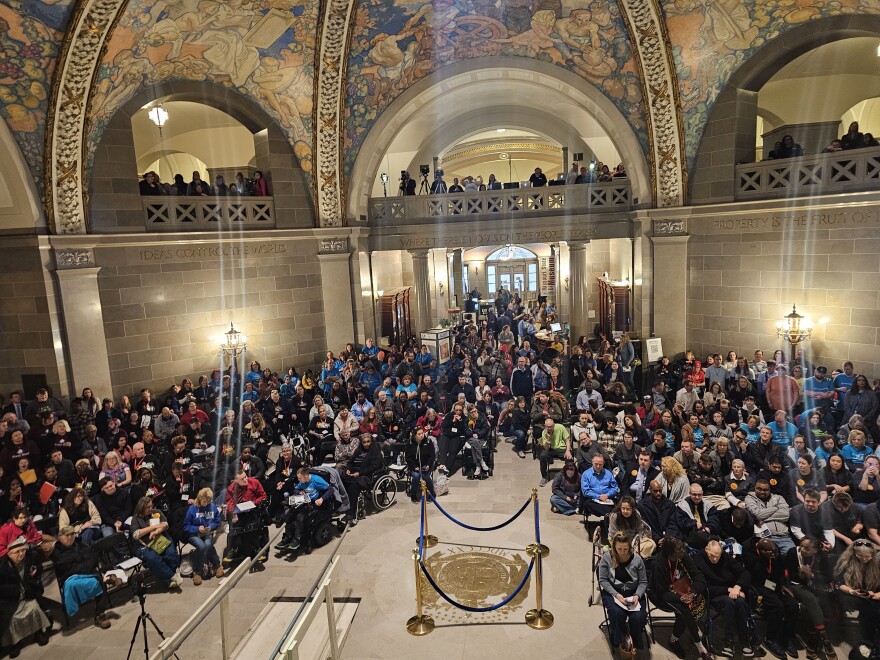 Several protestors are gathered in the Missouri capitol building. There are hundreds of people gathered.