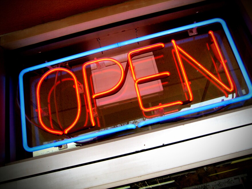 A neon open sign above a door.