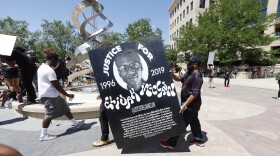 June 27, 2020: Demonstrators carry a giant placard during a rally and march over the death of Elijah McClain outside the police department in Aurora, Colo. (David Zalubowski/AP)