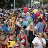 A big crowd walks down a Key West street during the Fantasy Fest masquerade march in 2018.