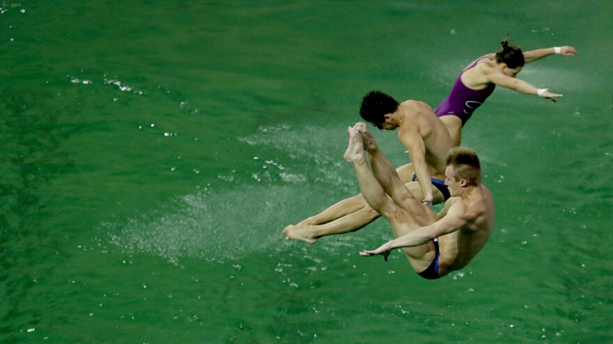 Divers take part in training before the men's synchronized 3-meter springboard diving final. The water in the pool was still green on Wednesday, but appeared to be returning to normal.