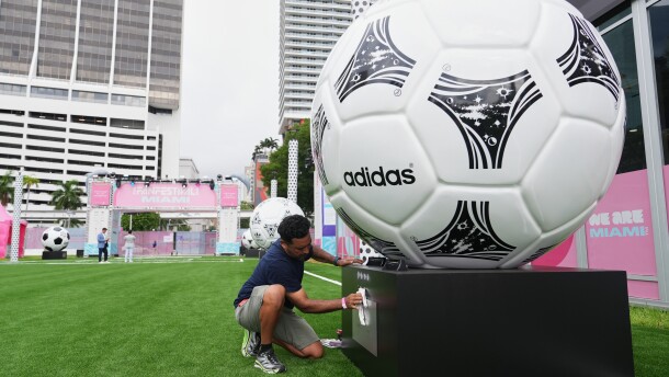 Jorge Gonzalez cleans a display featuring giant soccer balls, replicas from former World Cup tournaments, during a media preview of a Fan Festival for the World Cup soccer tournament, Wednesday, June 10, 2026, at Bayfront Park in Miami.