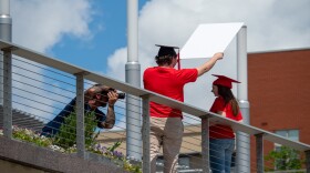 A photographer takes portraits of graduating seniors in the wake of the coronavirus pandemic, Saturday, May 16, 2020, in Cincinnati.