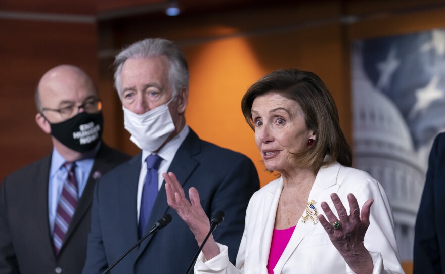 Massachusetts U.S. Reps. Jim McGovern (left) and Richard Neal look on as House Speaker Nancy Pelosi speaks to reporters in Nov. 2021.