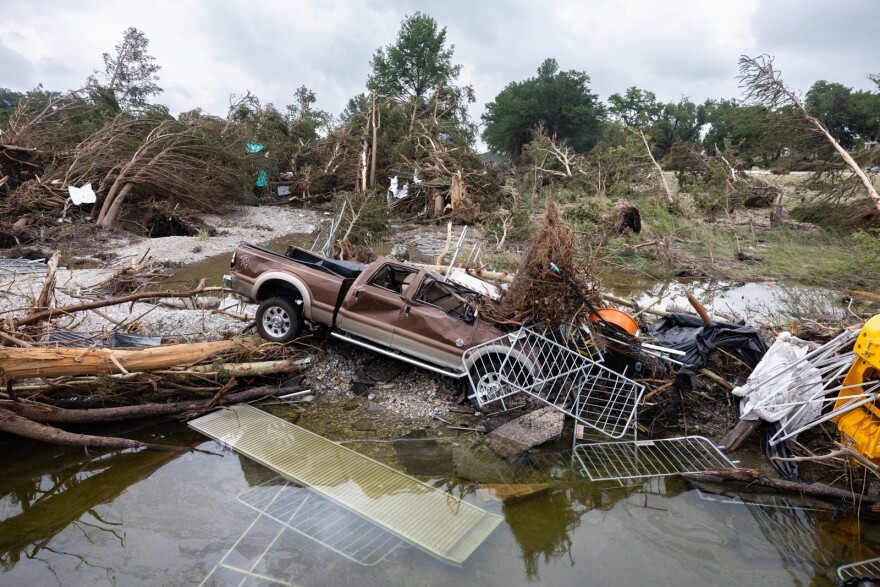 A truck sits sideways among metal fencing, trees and water in the aftermath of deadly flooding along the Guadalupe River. At least 120 people have been confirmed dead.