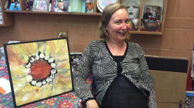Sandra Murphy-Pak shows one of her paintings. After she was diagnosed with ALS, she began painting with her feet.