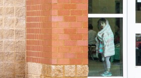 A child looks out a window at Knightdale High School, which has been converted into an evacuation shelter for people affected by Hurricane Florence in Kinghtdale, N.C., Sunday, Sep. 16, 2018.